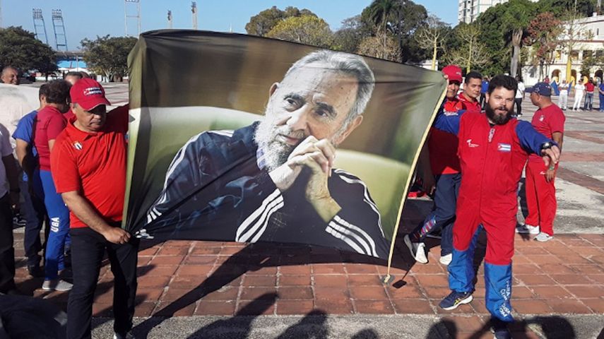Fidel Antonio Castro Smirnov (d) sosteniendo un retrato de su abuelo tras ejecutar el salto en paracaídas.