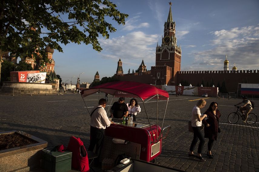 Un vendedor atiende un puesto de helado y agua en la Plaza Roja, con la Torre Spasskaya de fondo, en Mosc&uacute;, Rusia, el 16 de junio de 2020.&nbsp;