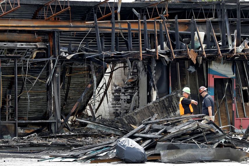 Dos trabajadores eval&uacute;an los da&ntilde;os causados a una tienda de art&iacute;culos deportivos, el lunes 1 de junio de 2020, en Tampa, Florida, despu&eacute;s de que el negocio fuera saqueado e incendiado durante una protesta el s&aacute;bado por la noche.&nbsp;
