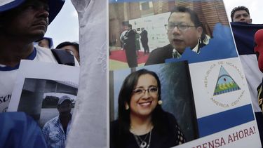 Vista de un cartel con fotos de la periodista Lucía Pineda Ubau (debajo), y de Miguel Mora, dueño del canal 100% Noticias, detenidos por el régimen de Daniel Ortega.