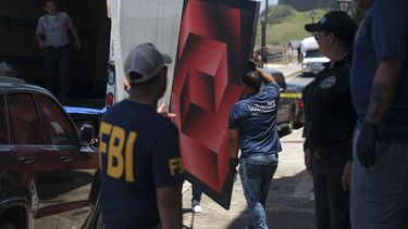 Una pintura es llevada a un camión mientras las autoridades francesas y miembros del FBI realizan una redada para recuperar el arte en la sede de la Fundación Michele Vasarely en San Juan, Puerto Rico, el 11 de abril de 2023.