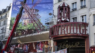 Esta fotografía muestra una grúa que levanta una de las cuatro velas temporales del molino de viento durante su instalación en la parte superior del cabaret Moulin Rouge tras el colapso de las anteriores, en París el 24 de junio de 2024.