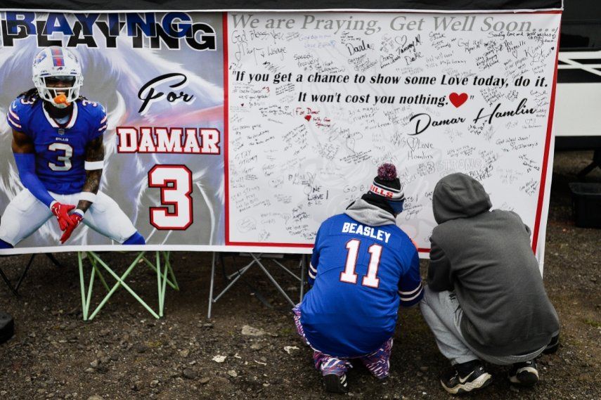 Aficionados dejan mensajes de apoyo para el safety Damar Hamlin (3), de los Bills de Buffalo, en una tarjeta de lienzo afuera del Estadio Highmark antes del partido con los Patriots de Nueva Inglaterra, el domingo 8 de enero de 2023, en Orchard Park, Nueva York.&nbsp;