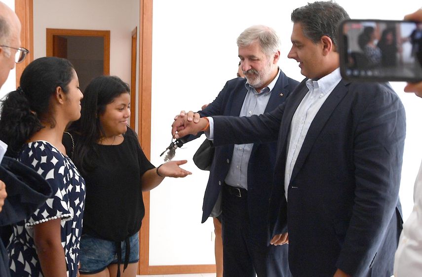 El alcalde de Génova, Marco Bucci (2-d), y el presidente de la región de Liguria, Giovanni Toti (d), entregan las llaves a la primera familia en la lista de personas desplazadas tras el derrumbamiento del puente Morandi en San Biagio de Bolzaneto, en Génova, Italia, hoy, 20 de agosto de 2018.