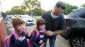 Anthony Sacco deja a sus hijas Angelina, de 7 años, (izquierda), y Victoria, de 5, para su primer día de clases en la primaria Fox Trail, el viernes 9 de octubre de 2020, en Davie, Florida. 