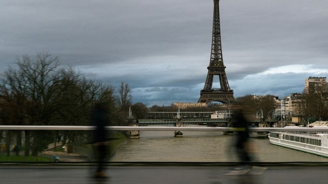 Los peatones caminan por el puente Grenelle-Cadets de Saumur con la Torre Eiffel al fondo bajo un cielo nublado en París, el 26 de enero de 2025.&nbsp;