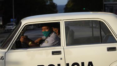 Agentes de policía con máscaras como precaución contra la propagación del nuevo coronavirus conducen una patrulla en una calle vacía durante el toque de queda en La Habana, Cuba, el martes 1 de septiembre de 2020. 