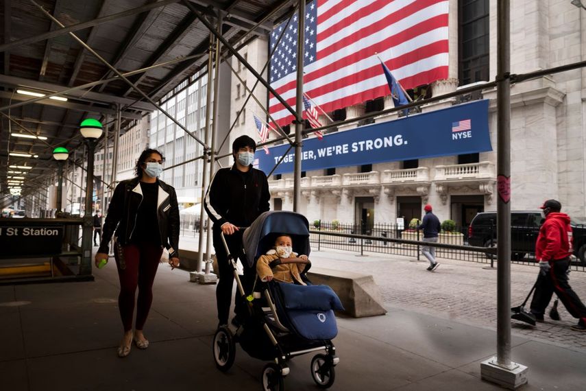 Una familia con cubrebocas pasa frente a la Bolsa de Valores de Nueva York.&nbsp;