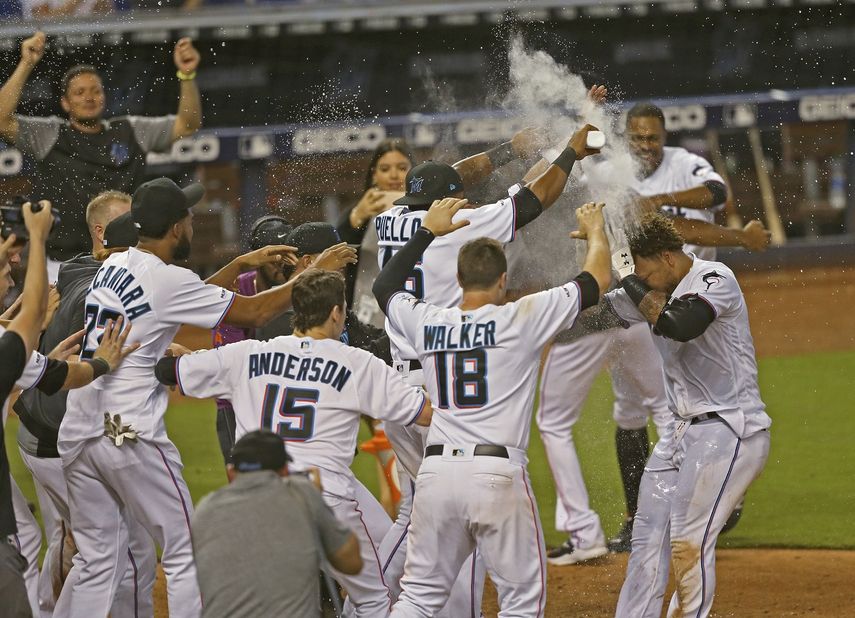 El colombiano Harold Ramírez, derecha, de los Marlins de Miami, es recibido por sus compañeros en el plato después de conectar un jonrón solitario en el 12do inning del encuentro con los Mellizos de Minnesota , el jueves 1 de agosto de 2019, en Miami.