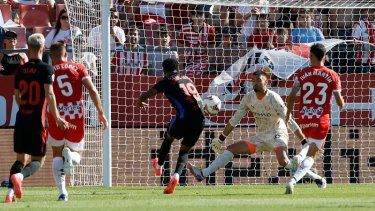 Lamine Yamal (centro) anota el primer gol del Barcelona ante Girona en la Liga española, el domingo 15 de septiembre de 2024, en Girona.