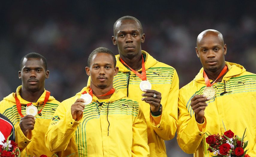 Los atletas jamaicanos (de izquierda a derecha) Nesta Carter, Michael Frater, Usain&nbsp;Bolt, y Asafa Powell posan en el podio con sus medallas de oro tras ganar en la final de relevos 4x100 durante los Juegos Olímpicos de Pekín 2008