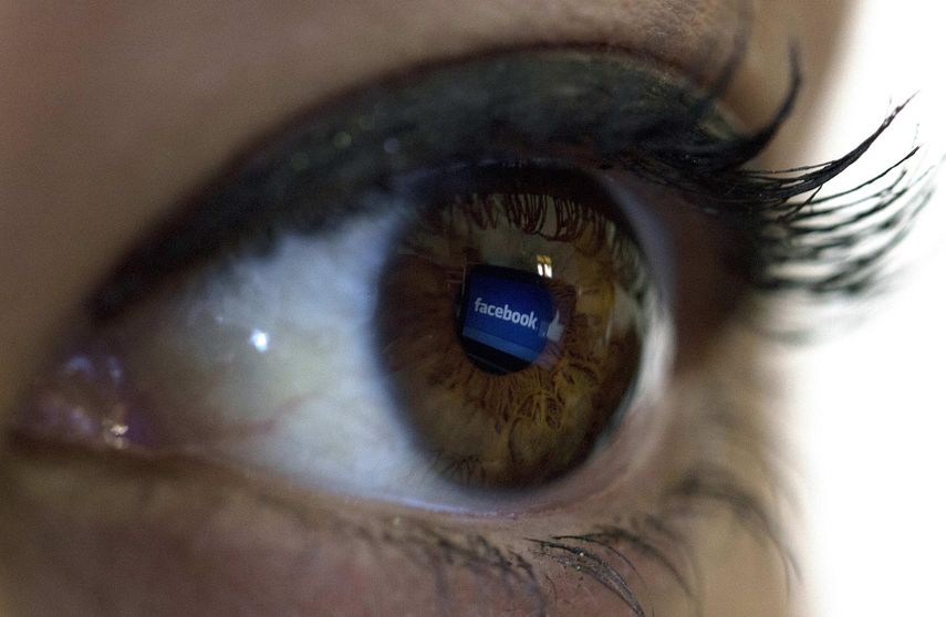 Vista del reflejo del logo de la red social&nbsp;Facebook en el ojo de una mujer.&nbsp;