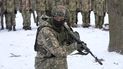 Un instructor capacita a miembros de las fuerzas de defensa de Ucrania, en un parque de Kiev, el sábado 22 de enero de 2022. 