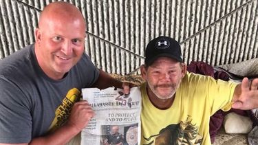 El oficial Carlson junto a Phil con una copia del artículo del Tallahassee Democrat.