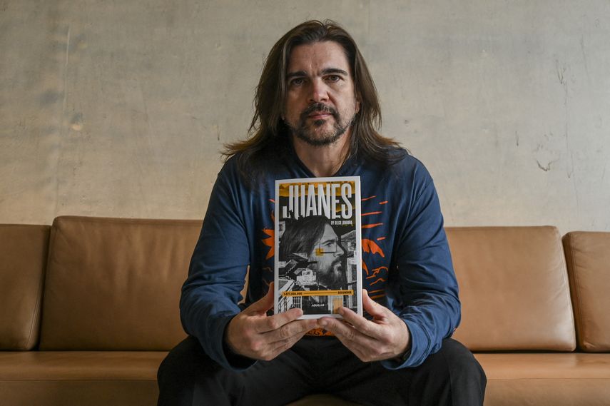 El músico colombiano Juanes posa con su libro biográfico del escritor Diego Londoño en Bogotá el 14 de septiembre de 2022.