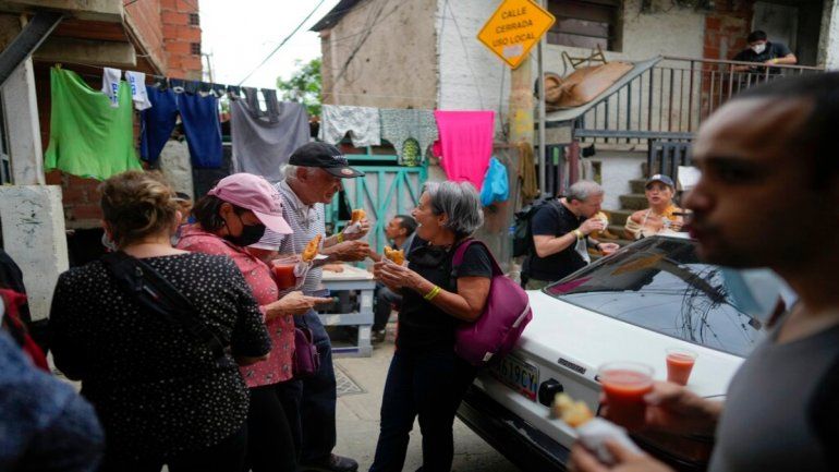 Turistas comen empanadas durante un recorrido organizado por el barrio San Agustín de Caracas, Venezuela.