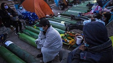 Personas acampan mientras esperan para rellenar cilindros de oxígeno vacíos en Villa El Salvador, en las afueras del sur de Lima, el 25 de febrero de 2021, en medio de la pandemia del coronavirus COVID-19. Los familiares de los pacientes con COVID-19 están desesperados por oxígeno para mantener con vida a sus seres queridos durante una feroz segunda ola de la pandemia en Perú.