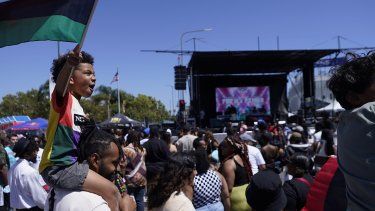 &nbsp;Julien James carga a su hijo, Maison, de 4 años, quien sostiene una bandera panafricana, durante una conmemoración del Juneteenth el 18 de junio de 2022 en Leimert Park en Los Ángeles.&nbsp;