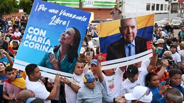 Ciudadanos sostienen afiches de María Corina Machado y Edmundo González en el cierre de campaña en el estado Zulia