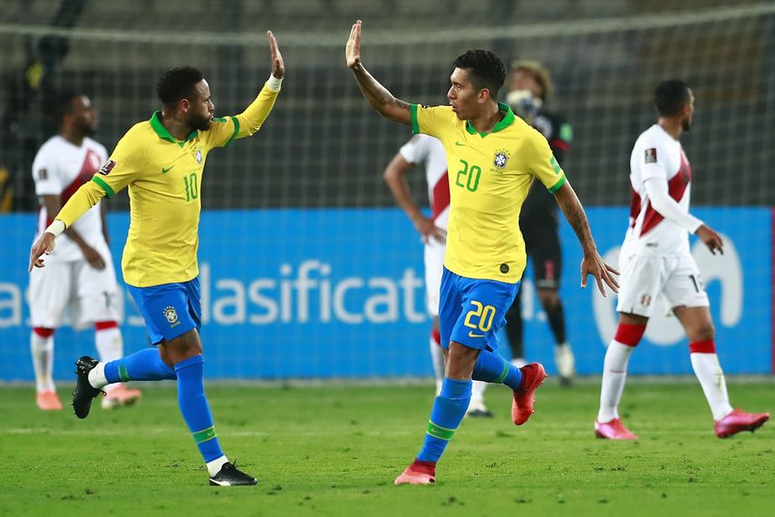 El brasileño Roberto Firmino (der.) celebra con su compañero Neymar durante un partido de fútbol clasificatorio sudamericano para la Copa Mundial de la FIFA 2022.