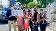 Lisandra Tejera, con lentes y tercera empezando por la derecha, con un grupo de ciudadanos cubanos frente a la embajada de EEUU en Georgetown, Guyana. En la imagen, Tejera y el resto de las familias protestan porque Estados Unidos no les concede una entrevista en la embajada a pesar de que ganaron la lotería de visas.