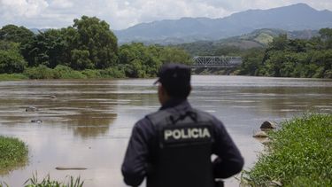 Un agente de la policía nacional salvadoreña observa el río La Paz en la frontera con Guatemala en La Hachadura, El Salvador, es parte de un despliegue de 800 policías y soldados para patrullar los puntos ciegos a lo largo de sus fronteras donde operan contrabandistas de migrantes y delincuentes transnacionales.