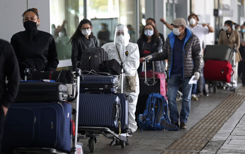 Una fila de viajeros antes de abordar un vuelo en medio de la pandemia.