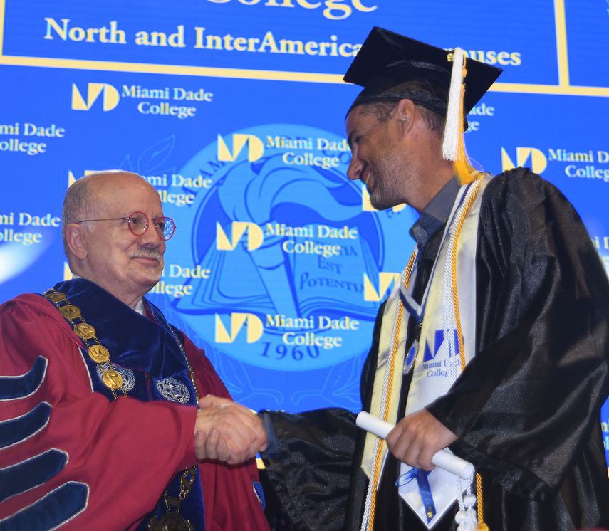 Dr. Eduardo Padrón entrega un diploma a un estudiante.&nbsp;