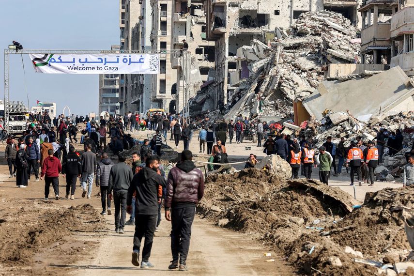 Una pancarta cerca de los escombros de un edificio derrumbado a lo largo de la calle costera al-Rashid de Gaza, da la bienvenida a las personas,  el 26 de enero de 2025.