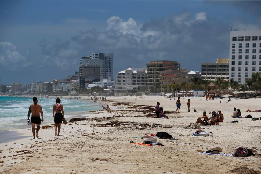 Turistas disfrutan de la playa el miércoles 18 de agosto de 2021 antes de la llegada del huracán Grace, en Cancún, México