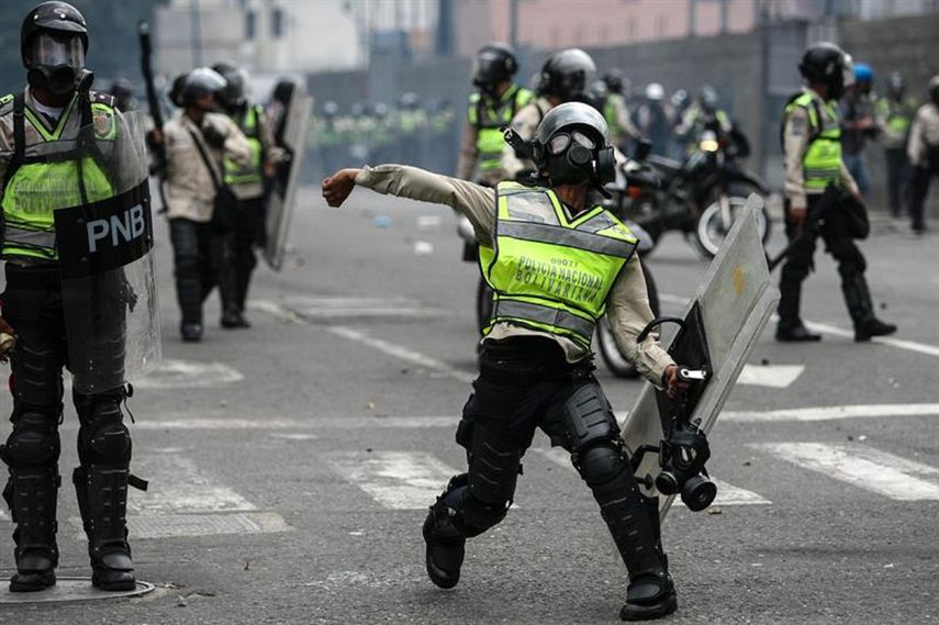Efectivos de la Guardia Nacional Bolivariana (GNB) lanzan gas lacrimogéno a los asistentes de la marcha opositora en Caracas