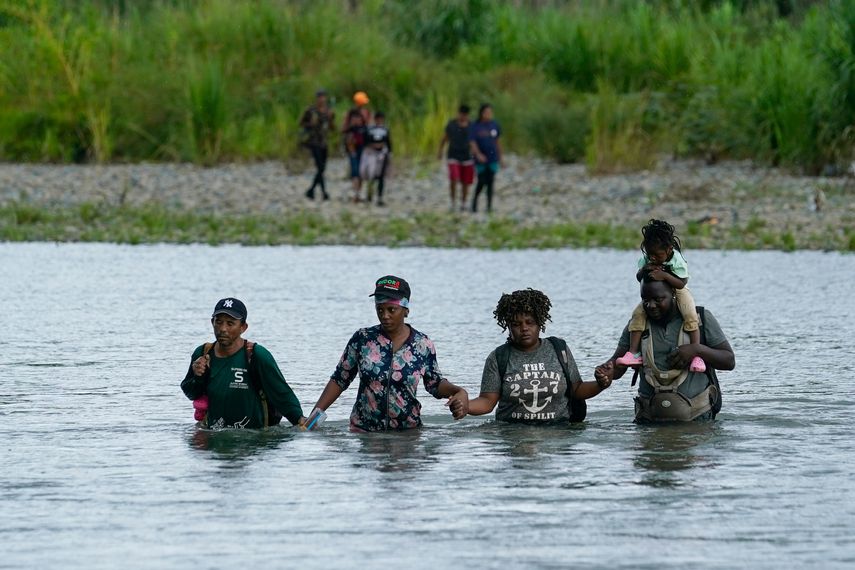 Migrantes haitianos atraviesan a pie el río Tuquesa, tras atravesar el Tapón del Darién, en Bajo Chiquito, Panamá, el miércoles 4 de octubre de 2023.