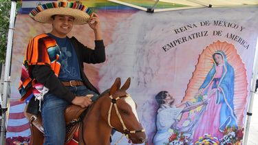 Jorge Islas posa montado sobre un caballo de plástico en frente de un mural con la imagen de la&nbsp;virgen&nbsp;de&nbsp;Guadalupe&nbsp;este 12 de diciembre en el centro histórico de Los Ángeles, California.