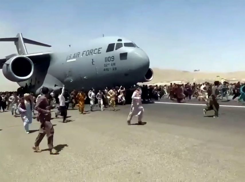 Cientos de personas corren junto a un avión militar de EEUU que se apresta a despegar en el aeropuerto de Kabul el lunes 16 de agosto del 2021, tras la toma del poder por parte del Talibán.&nbsp;