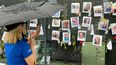 Un familiar ora frente fotografías de desaparecidos, cerca del edificio que colapsó en Surfside, al norte de Miami Beach.