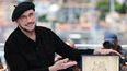 El actor, director y guionista John Travolta posa con la Palma de Oro honorífica que otorga el Festival de Cine de Cannes.