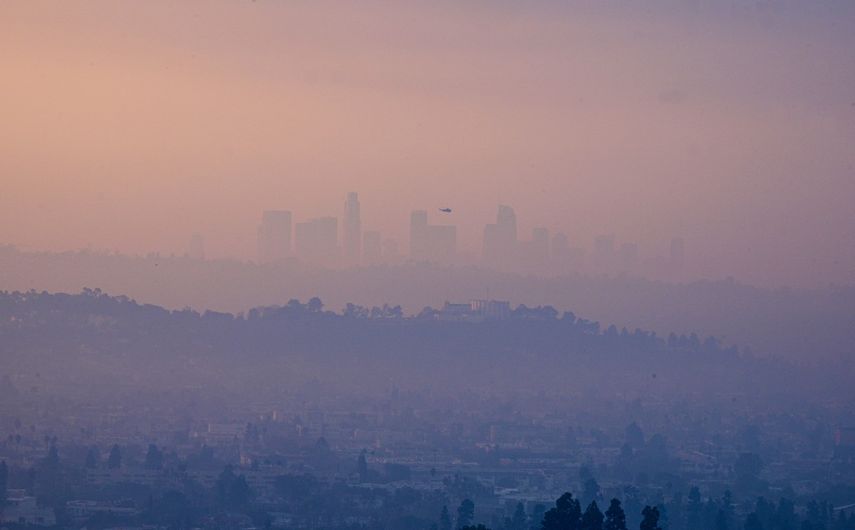 Un helicóptero sobrevuela el centro de Los Ángeles, California, cubierto de humo por el incendio de Eaton, el incendio de Palisades y otros incendios más pequeños, como se ve desde Glendale, California, el 9 de enero de 2025.&nbsp;&nbsp;