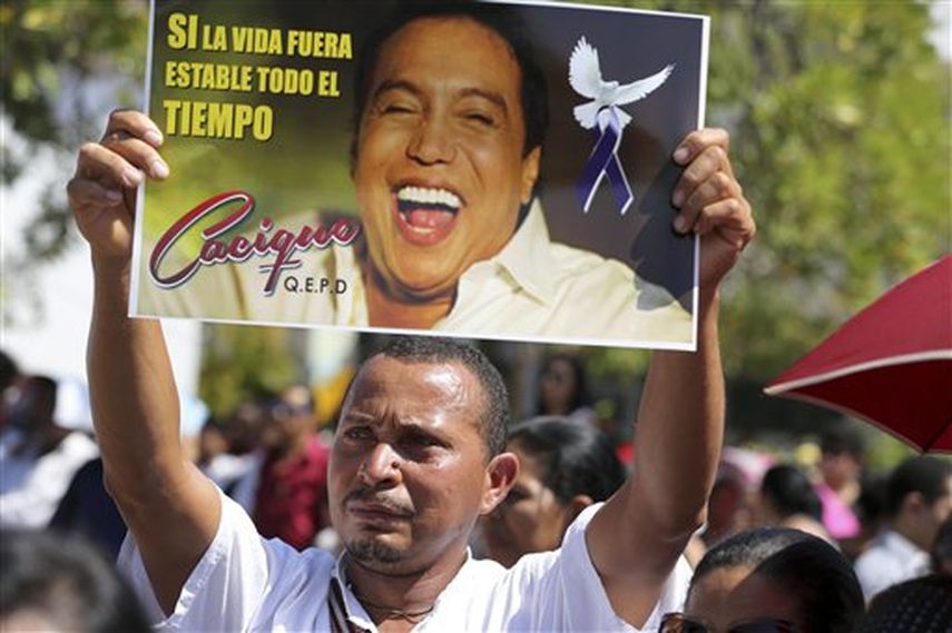 Un hombre carga un cartel del cantante y compositor Diómedes Díaz durante su funeral en la plaza central de Valledupar, Colombia, el 25 de diciembre de 2013. (AP)