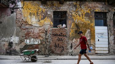 Un hombre pasa junto a un graffiti que dice Necesitas ser feliz del artista cubano Mr. Sad en La Habana, el 12 de diciembre de 2024.