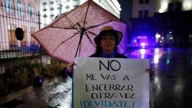 Una mujer sostiene una pancarta para oponerse a nuevos confinamientos por la pandemia del COVID-19 frente a la Casa Rosada.