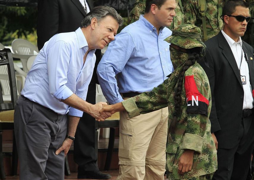 El presidente Santos da la mano a un guerrillero del ELN.&nbsp;