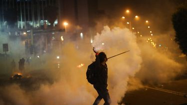 Un manifestante devuelve una lata de gas lacrimógeno lanzada por la policía para dispersar a inconformes el jueves 12 de noviembre de 2020, los cuales intentan aproximarse al Congreso en una protesta contra la remoción del presidente Martín Vizcarra, en Lima, Perú.