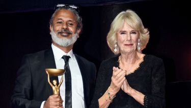 El escritor de Sri Lanka Shehan Karunatilaka posa junto a la reina consorte Camila después de ganar el premio Booker británico por su novela Las siete lunas de Maali Almeida, durante la ceremonia de entrega el 17 de octubre de 2022.