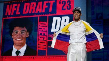 El cornerback Christian González parado en el escenario muestra los colores de la bandera de Colombia en su traje tras convertirse en la 17ma selección por parte de los Patriotas de Nueva Inglaterra durante el primer día del draft, el jueves 27 de abril del 2023.