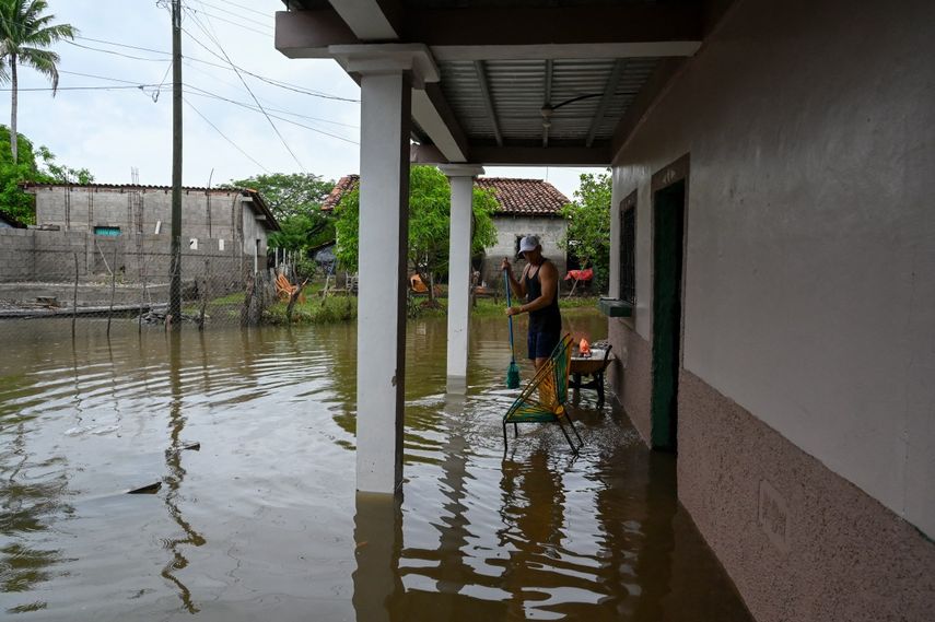 Un hombre se encuentra afuera de una casa inundada en la comunidad El Cubulero, municipio de La Alianza, departamento de Valle, Honduras, el 21 de junio de 2024, luego del desbordamiento del río Goascorán debido a las fuertes lluvias. Las lluvias torrenciales en Centroamérica han dejado al menos 27 muertos en deslizamientos de tierra e inundaciones durante la semana pasada, principalmente en El Salvador, pero también en Guatemala y Honduras, dijeron funcionarios el viernes.