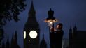 Un ingeniero británico de gas repara una lámpara de gas cerca de las Casas del Parlamento en el centro de Londres el 11 de noviembre de 2022.