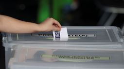 Una mujer deposita su boleto en elecciones presidenciales en Santiago de Chile, el domino 21 de noviembre de 2021.