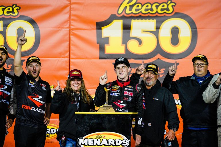 Flanqueado por sus padres Shanie y René y por los miembros de su escudería Rev Racing, Nick Sánchez celebra su victoria en la Reese’s 150, el sábado 23 de octubre del 2021 en el Autódromo de Kansas. 