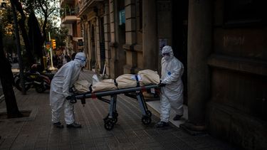 Trabajadores funerarios trasladan el cuerpo de un anciano fallecido por COVID-19 tras retirarlo de una residencia en Barcelona, España, el viernes 13 de noviembre de 2020. Los trabajadores de funerarias vuelven a verse sobrepasados por un brote de coronavirus en residencias y hospicios de toda Europa, lo que ha sumido a las autoridades y trabajadores de residencias en una carrera contrarreloj hasta que puedan comenzar las vacunaciones.&nbsp;