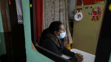 La migrante venezolana Yaquelin Timaure se ve reflejada en un espejo durante una entrevista en su casa en Bogotá, Colombia, el lunes 21 de diciembre de 2020.
